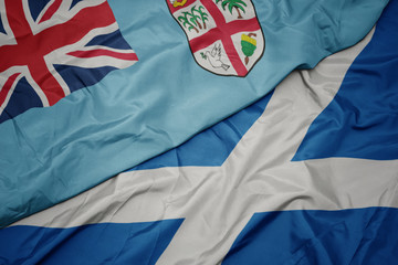 Fototapeta premium waving colorful flag of scotland and national flag of Fiji .