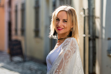 Portrait of beautiful blond woman dressed in  light clothes. Trendy girl posing in the street background - image