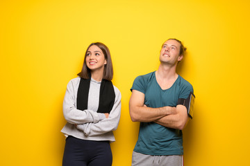 Group of athletes over yellow background looking up while smiling
