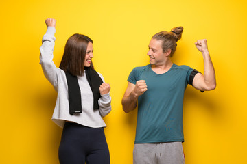Group of athletes over yellow background celebrating a victory