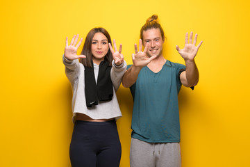 Group of athletes over yellow background counting nine with fingers