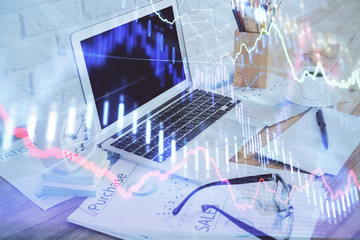 Stock market chart hologram drawn on personal computer background. Double exposure. Concept of investment.