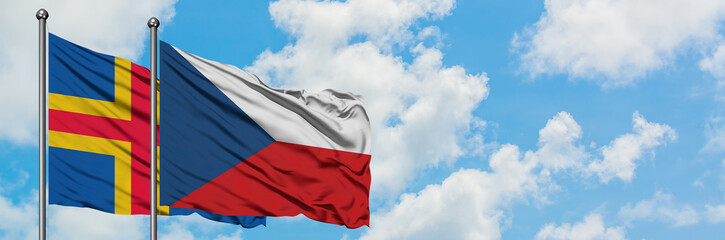Aland Islands and Czech Republic, flag waving in the wind against white cloudy blue sky together. Diplomacy concept, international relations.