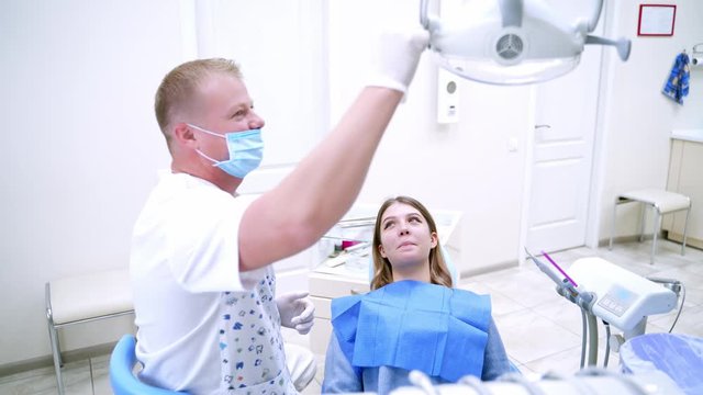 Woman having visit at the dentist. Dentist curing a female patient in the stomatology