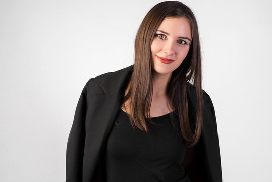 portrait of a young beautiful girl on a white background, black jacket thrown over her shoulders, straight dark hair, sexy look,