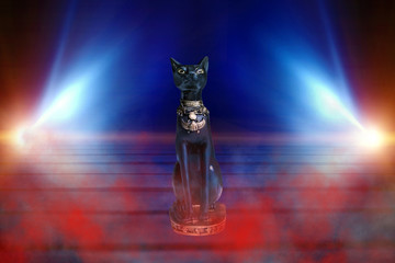 Egyptian goddess Bastet on a dark abstract background. The black figure of a cat in the rays of...