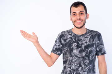 Portrait of happy young bearded Persian man showing something