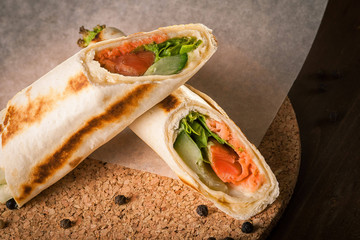 Salmon tortilla on baking paper with peppercorns