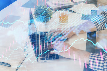 Multi exposure of graph with man typing on computer in office on background. Concept of hard work. Closeup.