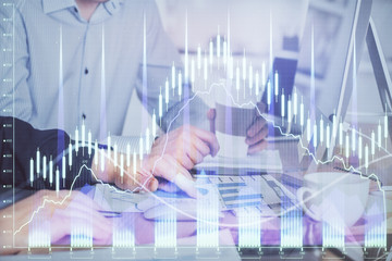 Multi exposure of chart with man typing on computer in office on background. Concept of hard work.