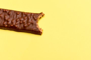 Tasty chocolate bar with a bite taken out isolated High calorie snack food