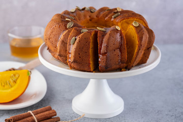 Pumpkin cake with honey on a gray background. Copy space.