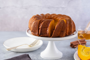 Pumpkin cake with honey on a gray background. Copy space.