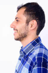 Obraz premium Closeup profile view of happy young bearded Persian hipster man smiling