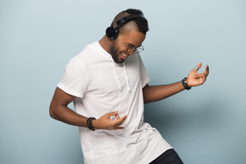 Overjoyed biracial man in earphones have fun dancing - Powered by Adobe
