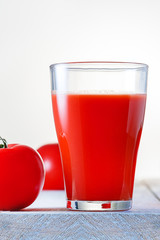 Tomato juice. Glass of fresh tomato juice on wooden table. Vertical image.