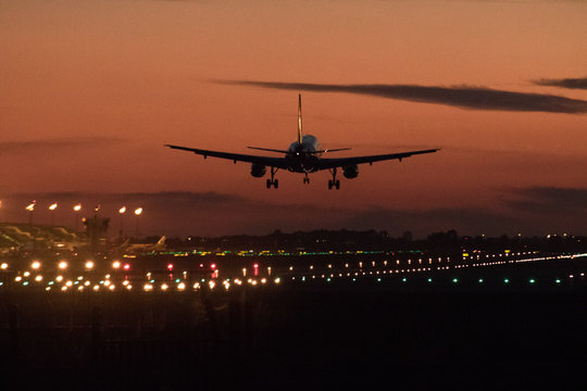 Airplane silhouette landing at the airport during sunser, Barcelona
