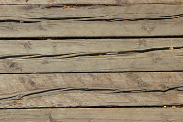 Texture of an old and heavily cracked wooden panels with multiple knots