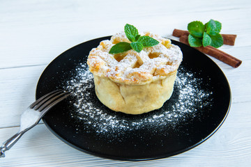 Homemade American Apple Pie Decorated with Powdered Sugar and Mint.