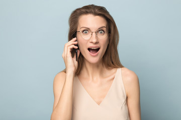 Fototapeta premium Amazed millennial woman shocked by unexpected news on cell
