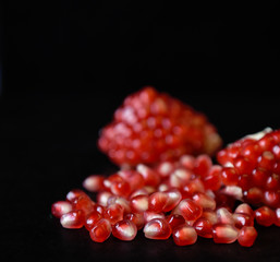 red pomegranate seeds on black background