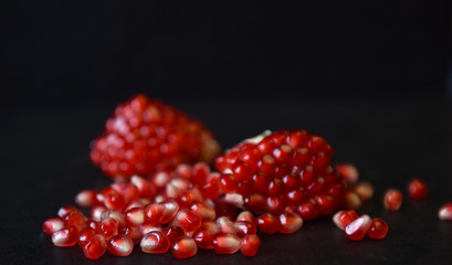 red pomegranate seeds on black background