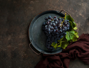 dark bunch of grape with water drops in low light, red wine, dark photo with copy space