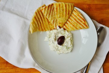 Obraz premium Greek tzatziki yogurt dip with grilled pita bread