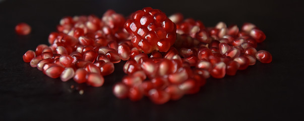red pomegranate seeds on black background