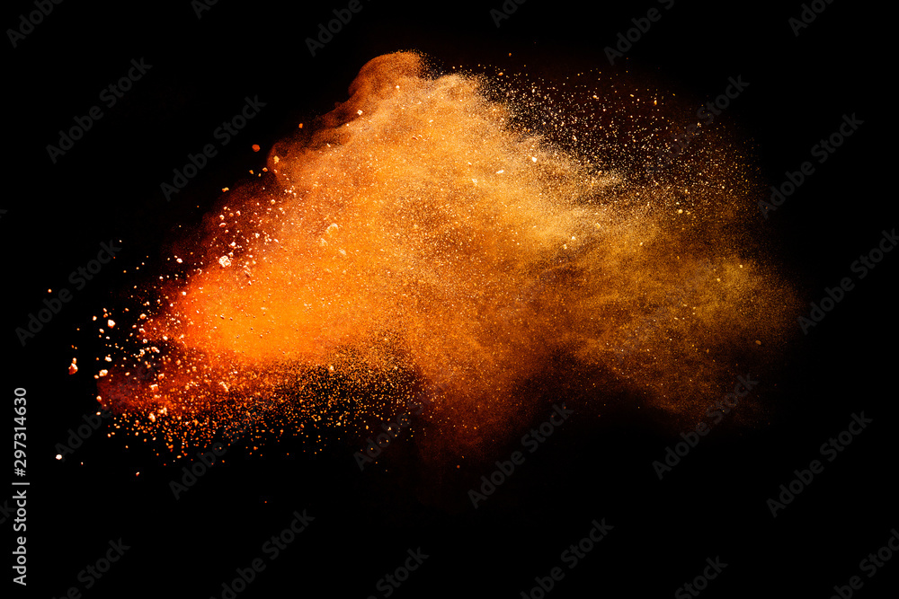 Wall mural abstract orange powder explosion isolated on black background.