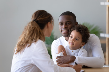 African American dad with little son visit female pediatrician