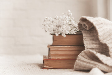 vintage books with airy flowers and a knitted sweater on the table