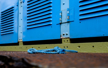 Shallow focus view of an abandoned industrial type rope seen in front of an old diesel powered freight locomotive.