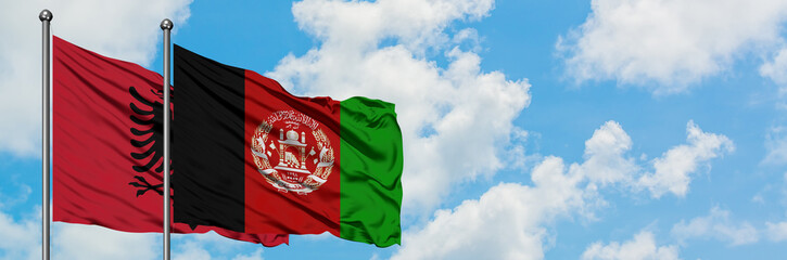 Albania and Afghanistan flag waving in the wind against white cloudy blue sky together. Diplomacy...