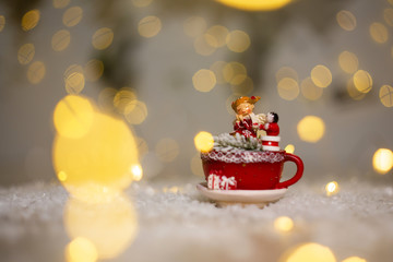 Decoration for Christmas holidays. Warm cozy atmosphere. Statuette of a red mug in which a snowman and a little man sit.