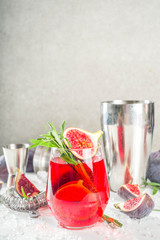 Fig autumn alcohol cocktail with cognac or liquor, rosemary, figs and honey, white marble table, with bar tools, copy space