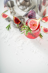 Fototapeta na wymiar Fig autumn alcohol cocktail with cognac or liquor, rosemary, figs and honey, white marble table, with bar tools, copy space