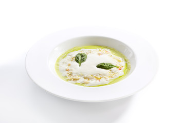 Green pea cream soup with mozzarella mousse top view