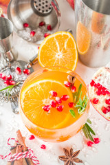 Orange and rosemary fizz with cider. Christmas festive mocktail. Autumn winter alcohol fruit and berry drink. White marble background with bar tools. Copy space