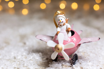 Decorative figurines of a Christmas theme. Snowman in a pink airplane with a propeller. Festive...