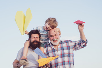 Happy fathers day. Childhood concept. Happy grandfather father and grandson with toy paper airplane...