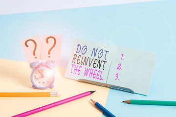 Writing note showing Do Not Reinvent The Wheel. Business concept for stop duplicating a basic method previously done Mini size alarm clock beside stationary on pastel backdrop