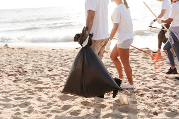 Photo of volunteers cleaning beach from plastic with trash bags