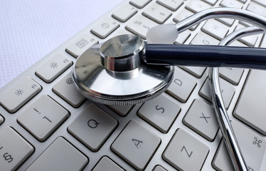  Close-up view of a medical stethoscope seen on a doctors computer keyboard showing detailed view...
