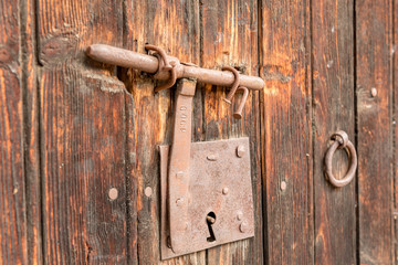 ood old door with round metal knobs for exterior design. Antique and grunge style. Brown wooden surface door photography image