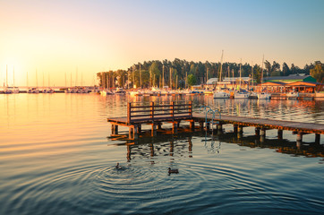 Boats docking in the marina at the Niegocin Lake during sunrise.. Wilkasy, Masuria , Poland. - obrazy, fototapety, plakaty