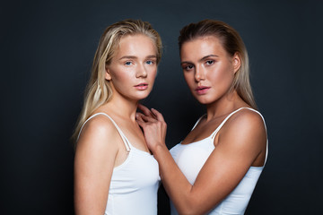 Young pretty women with natural clear skin and blonde hair. Two models wearing white shirt