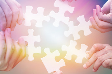 Autism and autistic ,child putting puzzle together. Hands of children students holding pieces of jigsaw as a symbol for  teamwork in school.