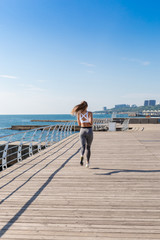 Sportive woman running on an embankment.