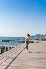 Young woman running on the sea side.